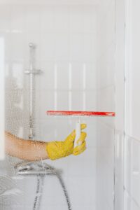 housekeeper cleaning a bathroom shower